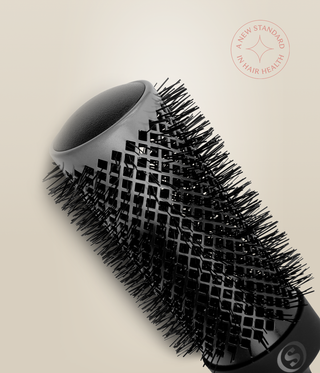 Close-up of a wide HeatSense Round Brush barrel, showing its open end, vents and black bristles.