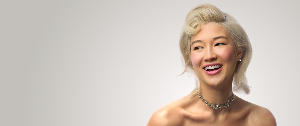 Model with short blonde hair styled in a side-swept wave.